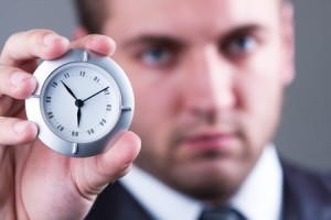 40893594 - adult serious businessman shows a little white clock