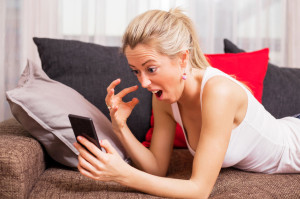 52348623 - woman going crazy over something on her phone